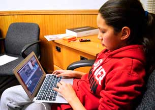 Young female student editing on laptop computer