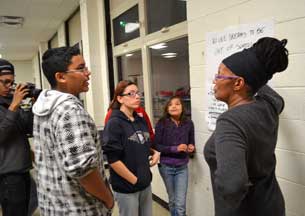 Three students present ideas for project on large paper